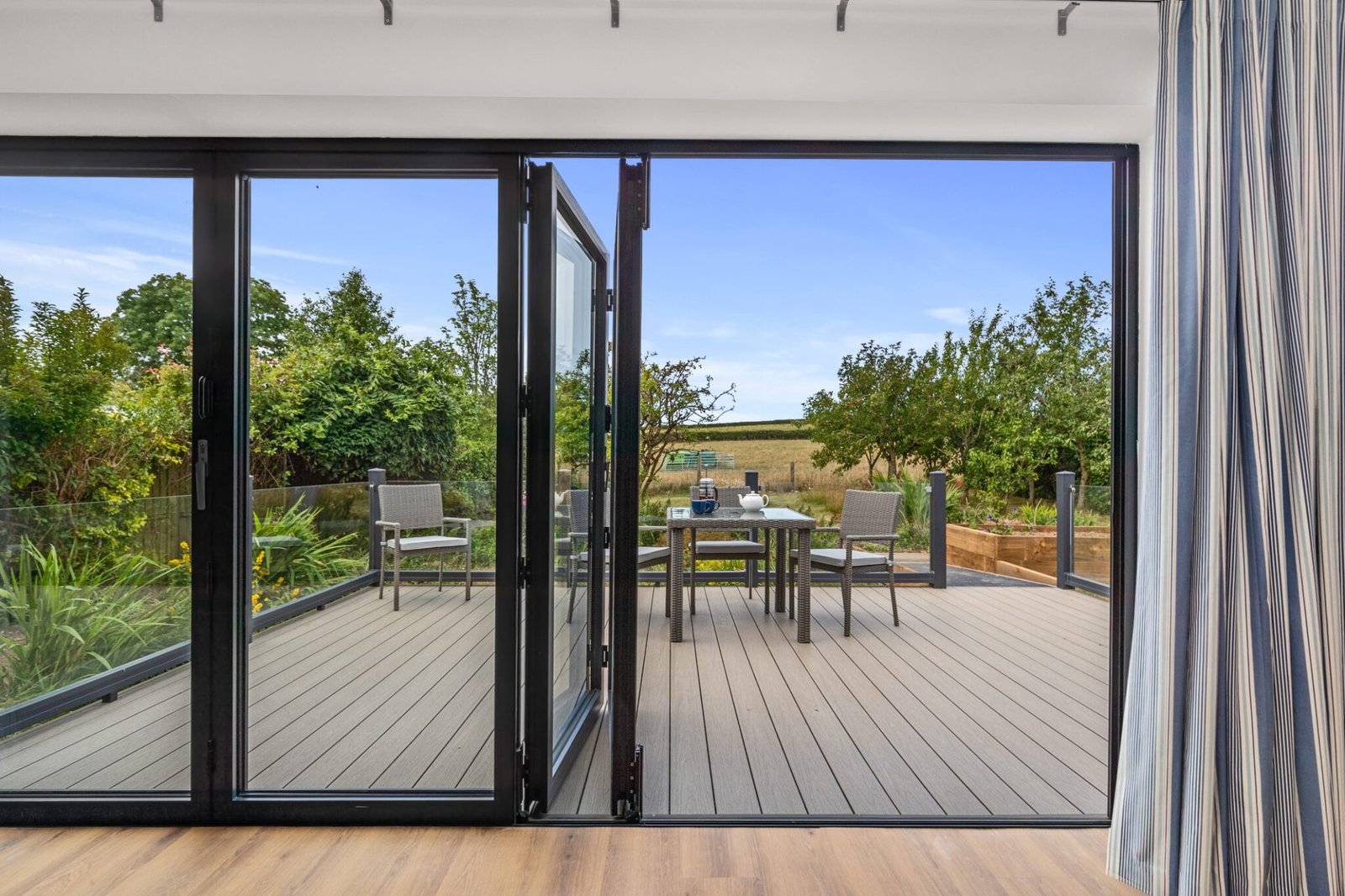 Folding-sliding doors linking lounge to spacious outdoor deck